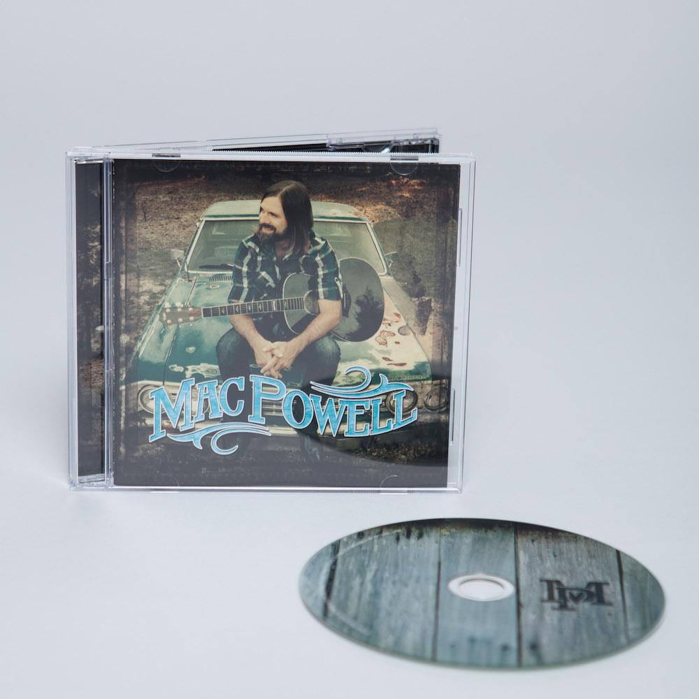Mac Powell self titled album with a photo of Mac sitting on a chevy car with a guitar displayed with the CD.
