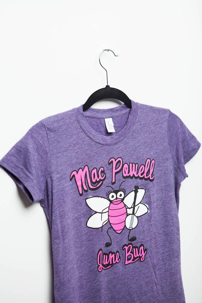 Side shot of a purple ladies Mac Powell tee that reads "Mac Powell June Bug"